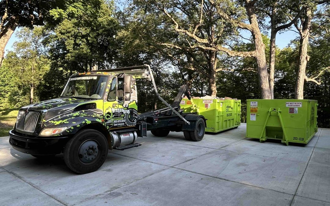 Photo of a truck with two dumpsters during a delivery and/or dumpster swaps, one of the many areas covered in our dumpster rental FAQ guide.